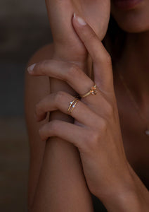 Woman wearing 10-karat solid gold rings from Carré. Two of the rings are set with diamonds, and the third is with a big champagne quartz gemstone