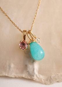Woman with a flower shaped blue earring. The earring is made of a Prasiolite gemstone and Amazonite gemstones