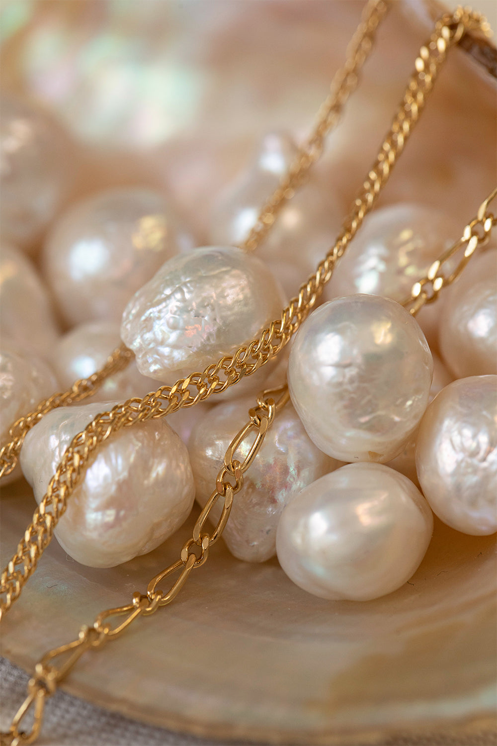 Bracelets in 9 karat solid gold from Carré laying on pearls.