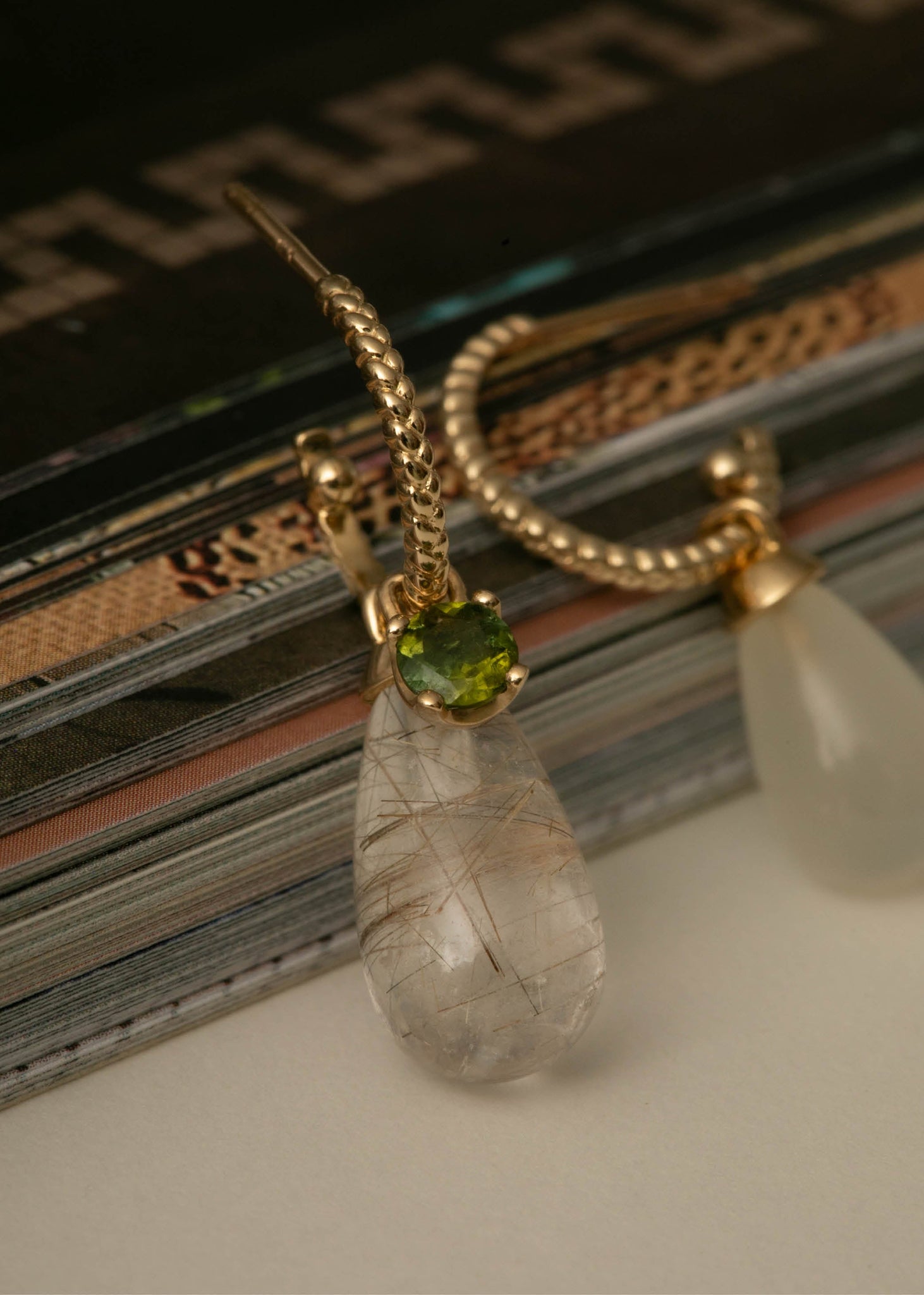 Woman wearing a gold plated sterling silver long Mirage earring with three rows of the yellow golden rutile quartz gemstone