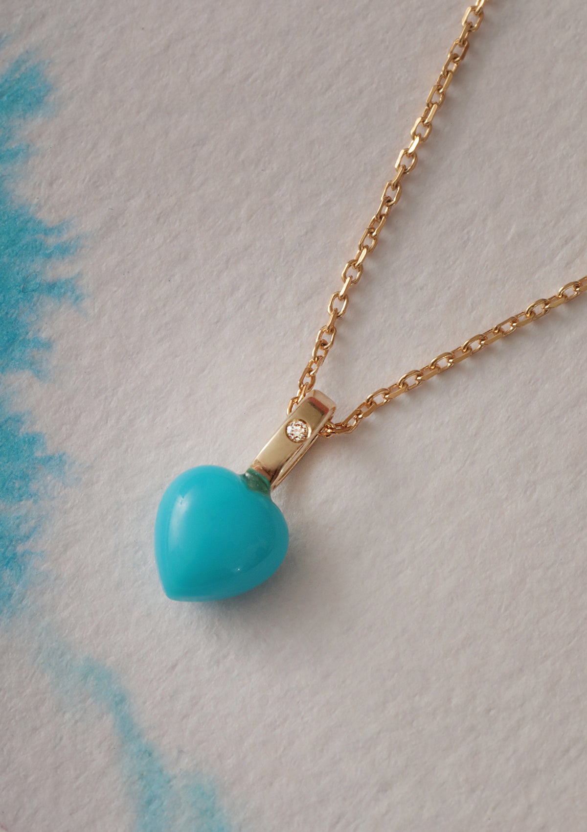10 karat solid gold heart pendant from Carré. A heart shaped turquoise gemstone set with a diamond.