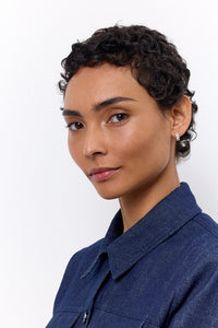 Woman in a blue denim suit wearing a small creol style hoop from Carré in sterling silver