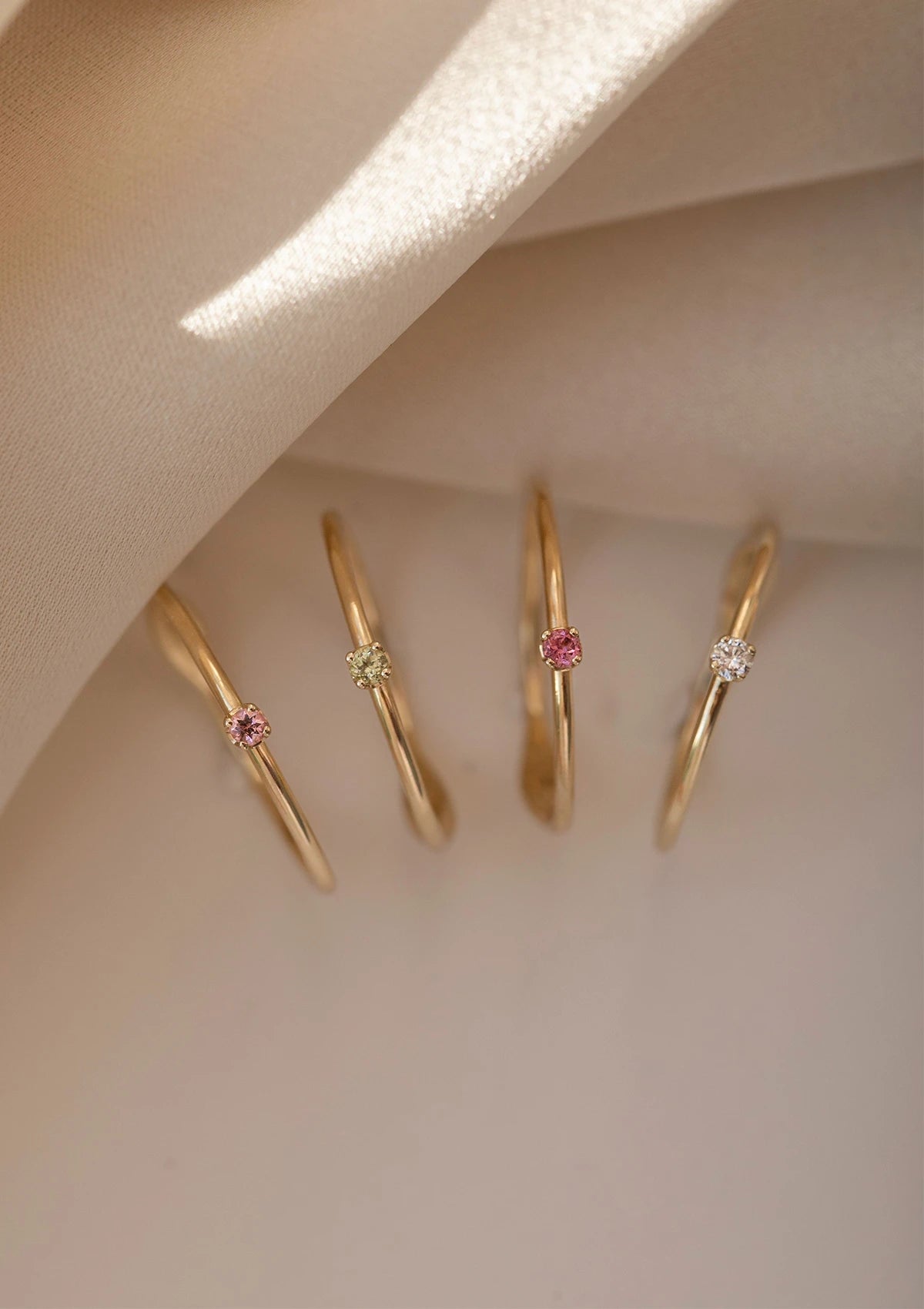 Four 10 karat gold rings from Carré set with colourful tourmaline gemstones and one with a diamond
