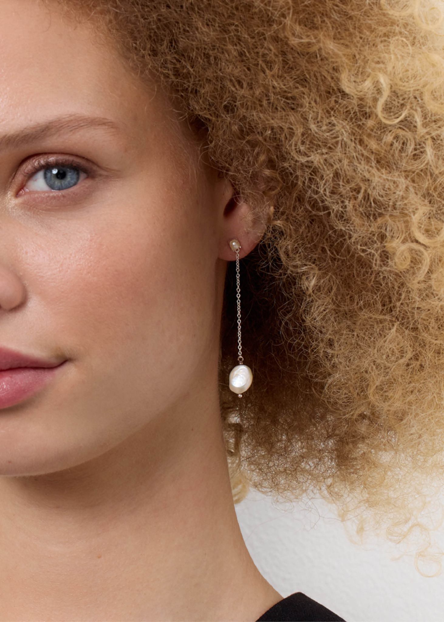 Long silver dangling pearl earring in a Scandinavian style