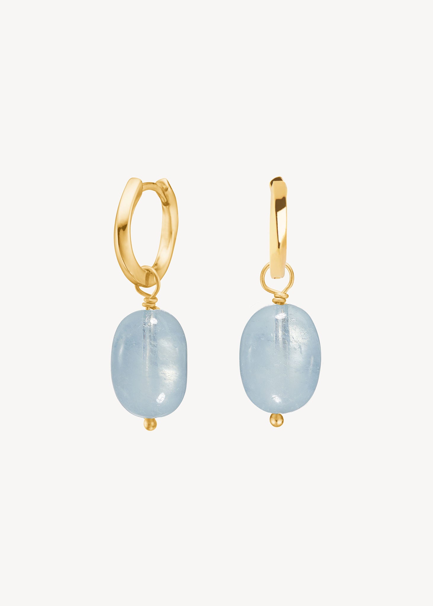 Diani earrings in gold plated sterling silver from Carré jewellery set with large blue aquamarine gemstones on hoops