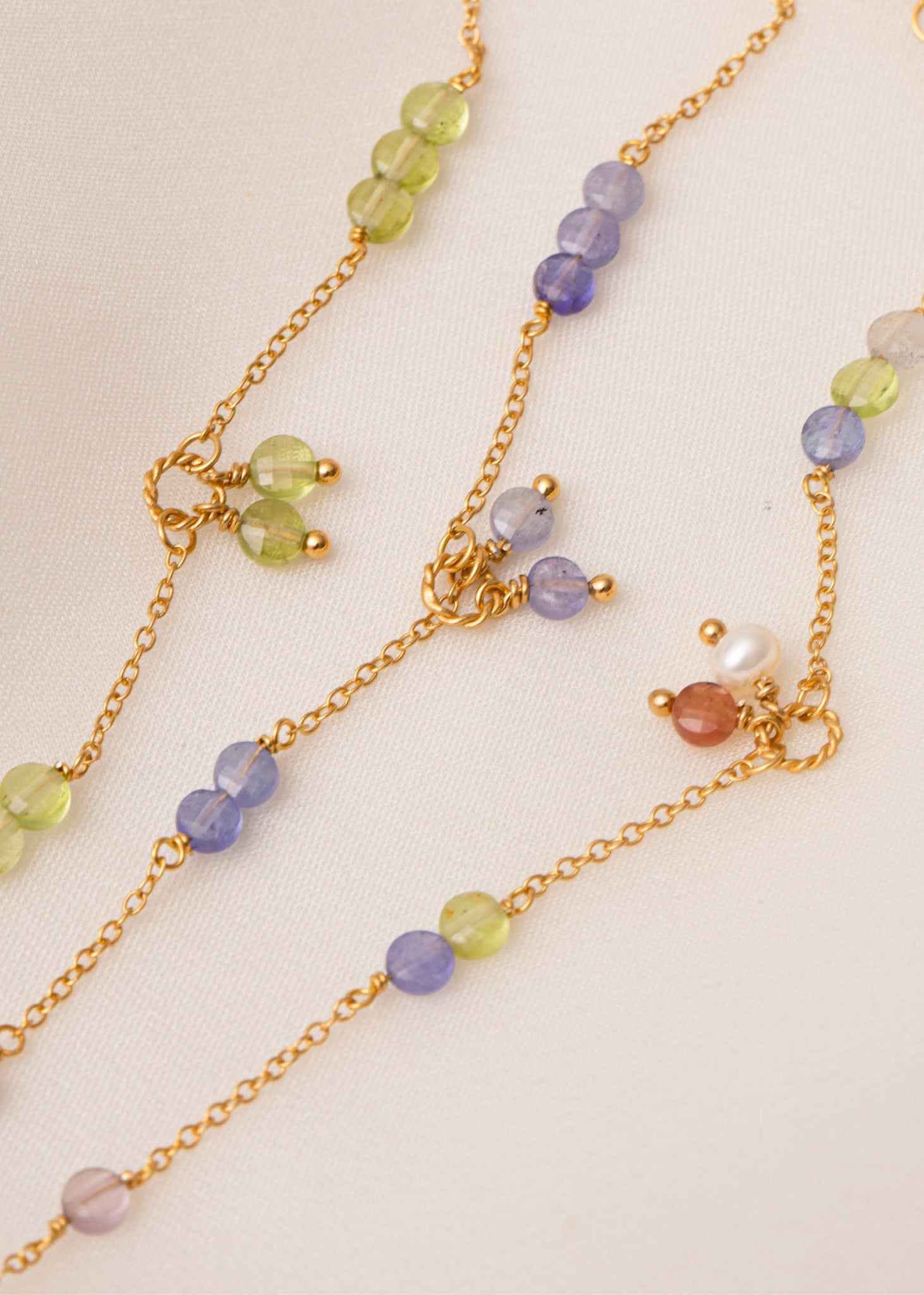 gemstone bracelets in danish design from carré jewellery with purple tanzanite and peridot in gold 