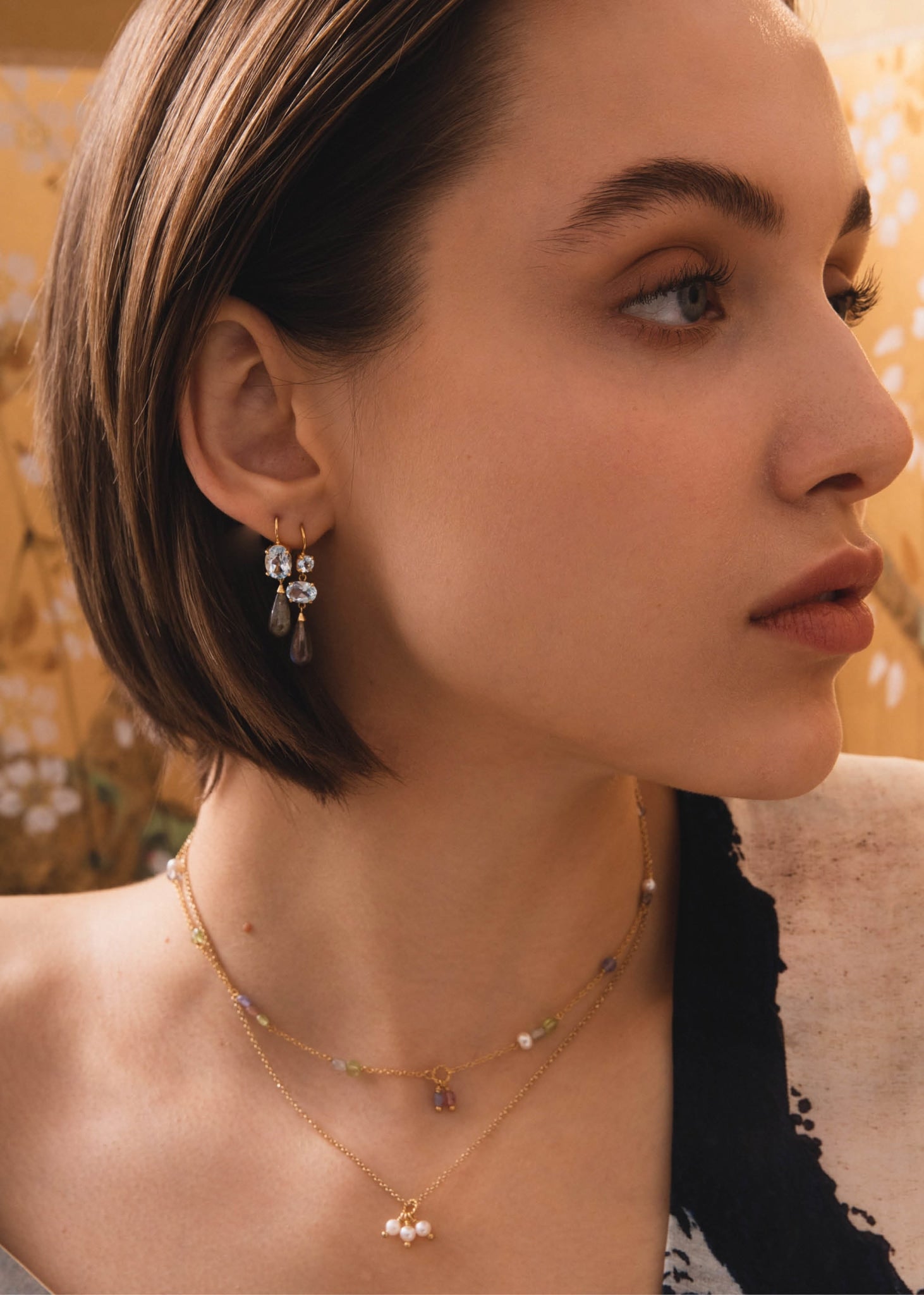 Kvinde med smuk guld halskæde fra carré jewellery med pastel farvede ægte ædelsten og perler