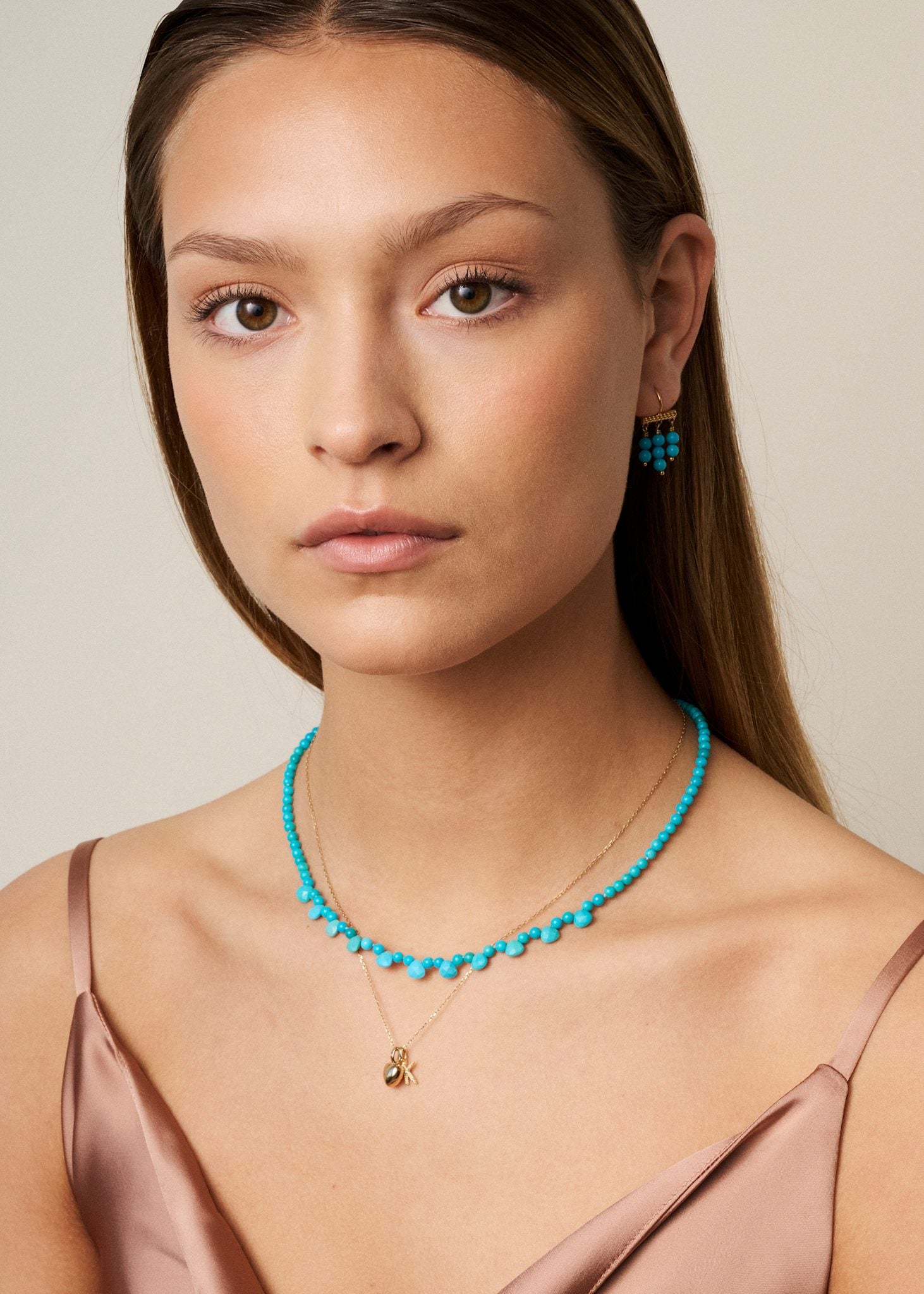 Ung kvinde med turkis smykker fra carré jewellery i guldbelagt sterling sølv, som er december måneds fødselssten