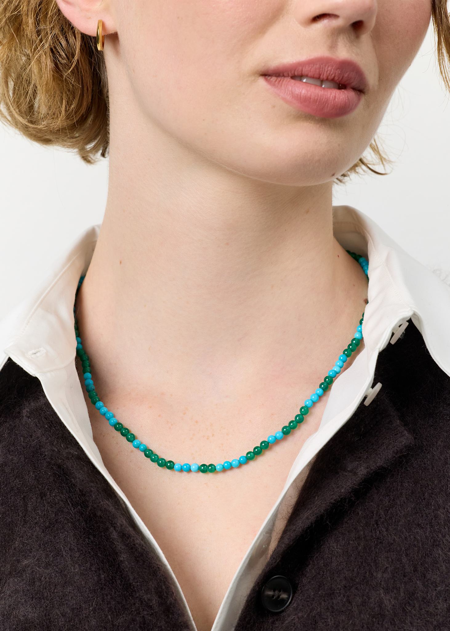 Ung kvinde med Safari halskæde fra carré jewellery med blå turkis ædelsten og grønne agat ædelsten og en guldbelagt sterling sølv lås