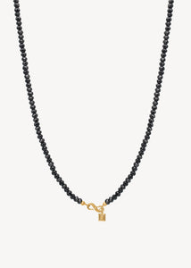 elegant halskæde med ægte sorte spinel ædelsten, der glitrer i lyset med en guldbelagt sterling sølv s-lås fra carré jewellery, perfekt gave til hende 