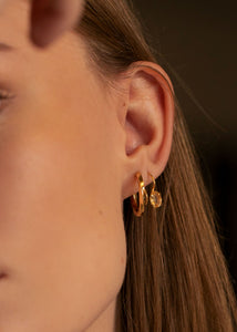 Woman wearing gold plated silver hook earrings with a golden facet-cut citrine gemstone