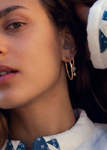 Kvinde med store hoop øreringe i creol design med snoet design og klik lås i guldbelagt sterling sølv fra carré jewellery 