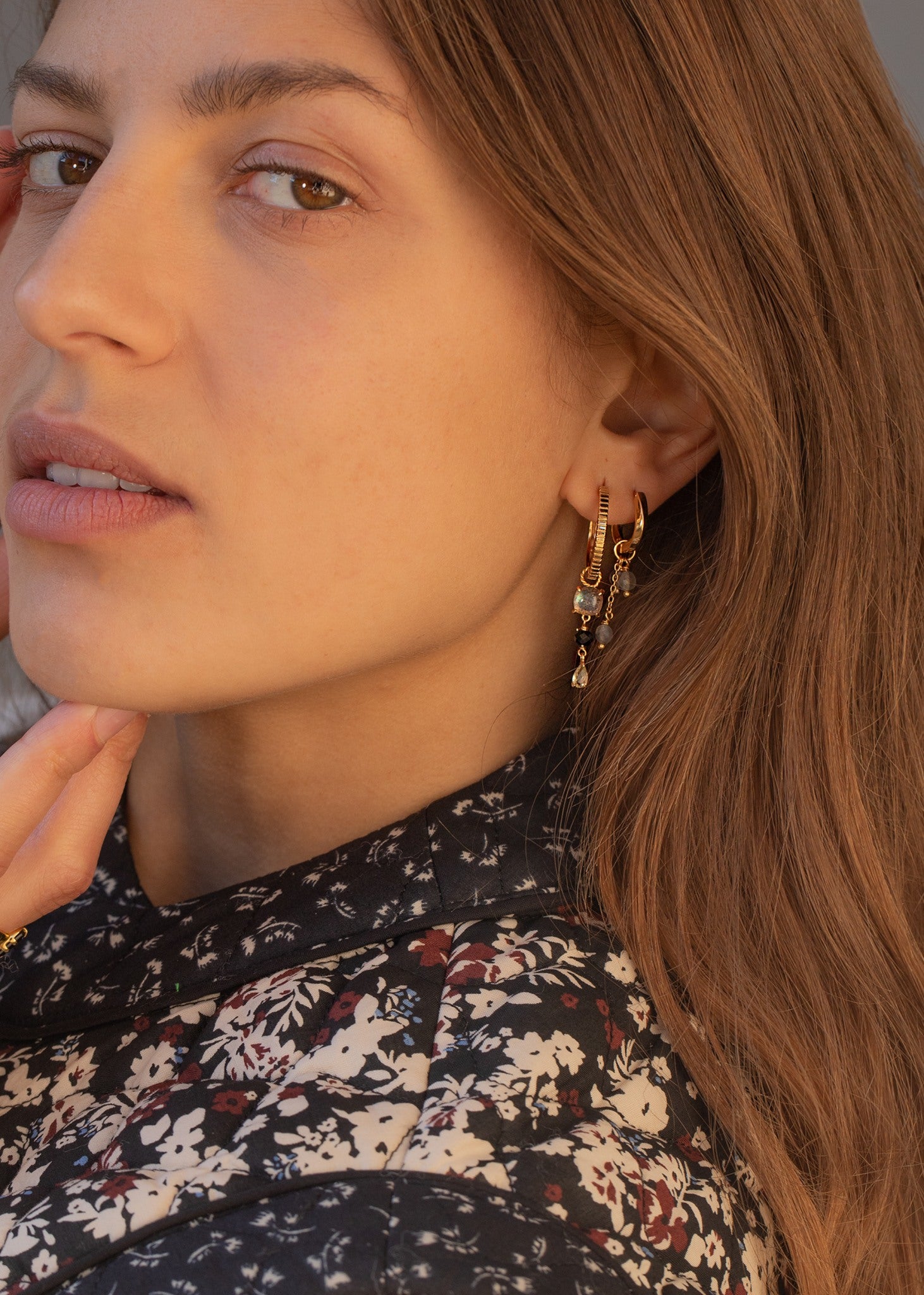 Kvinde med lange hængeøreringe i guld med labradorit ædelsten fra carré jewellery på udsalg 