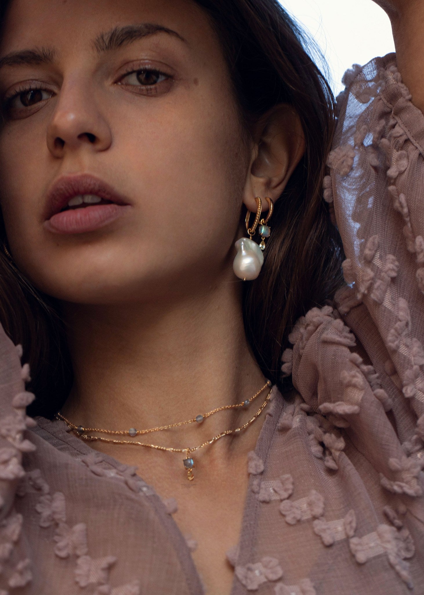 Kvinde med hoops og charms hængeøreringe fra carré jewellery med stor barok ferskvandsperle og maeve charm med ægte ædelsten i guld 
