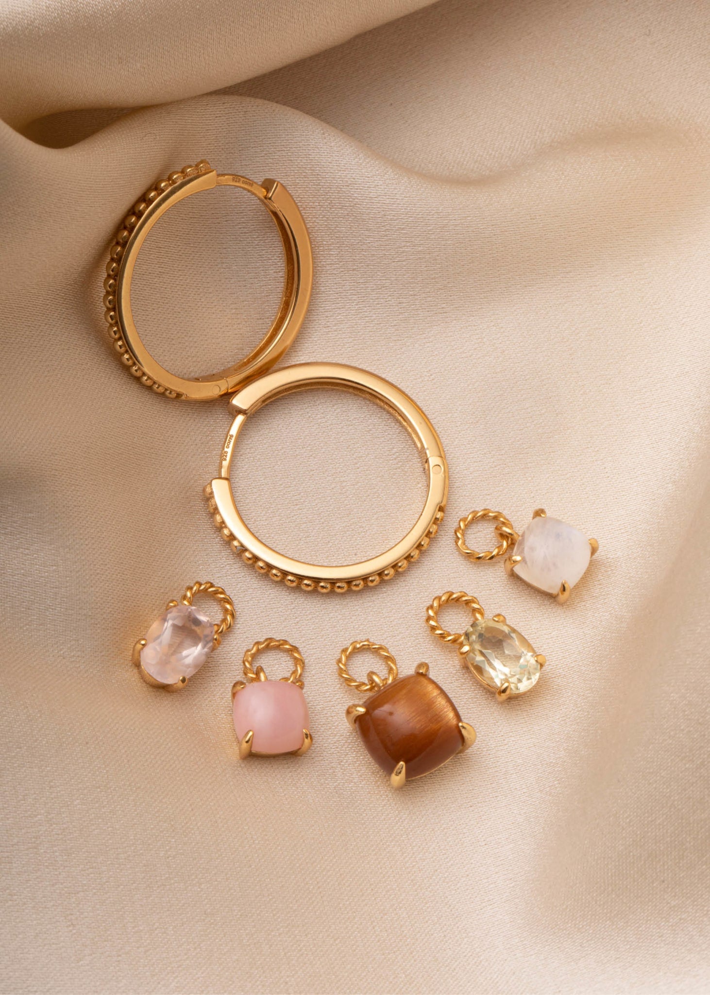 Hoops og charms fra carré jewellery i guld med månesten og solsten 