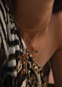 Woman with a gold pendant for necklaces set with mixed facet cut gemstones on chains