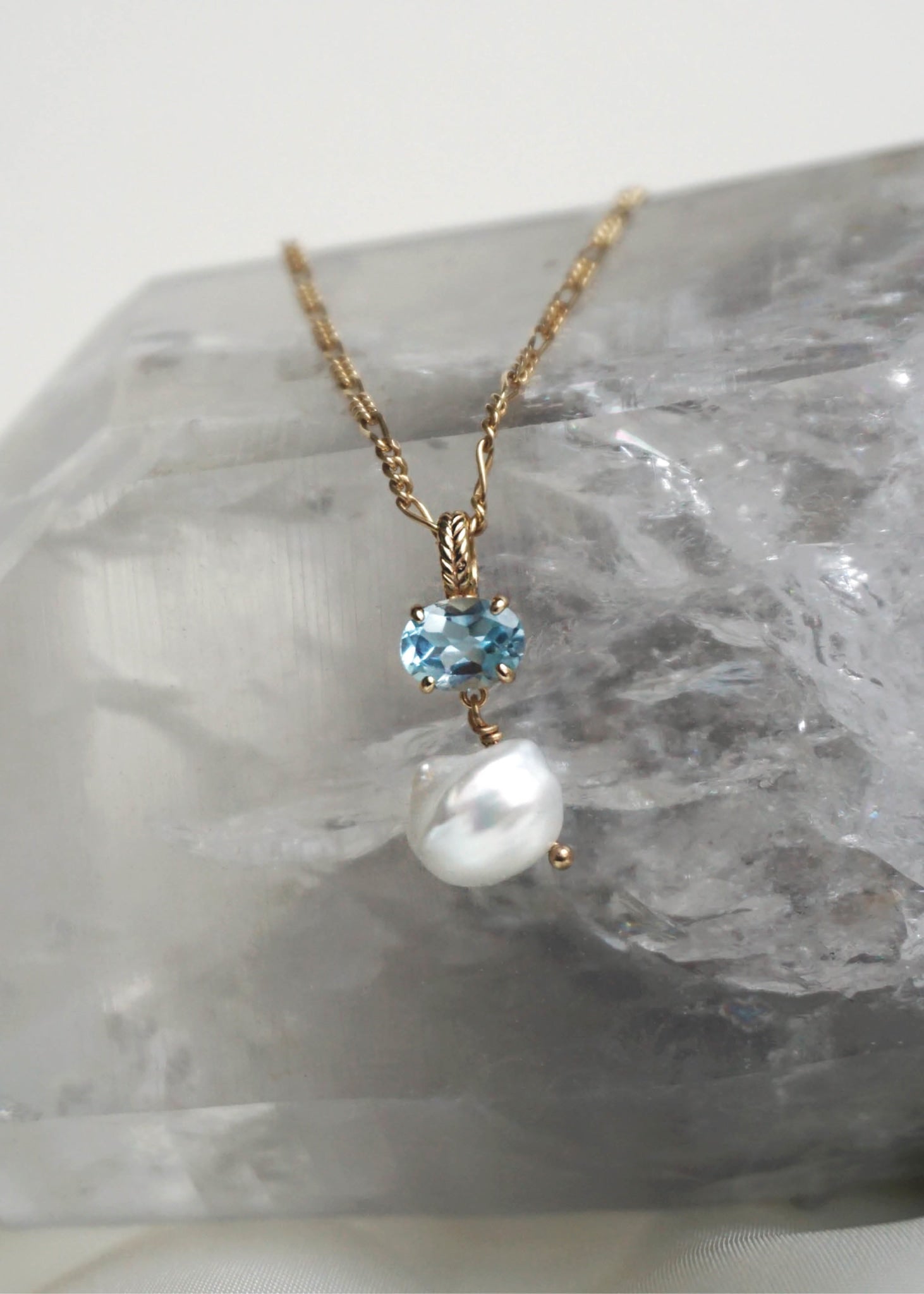 Mira vedhæng i guld fra Carré Jewellery sat med Blå Topas og en ferskvandsperle i keshi stil