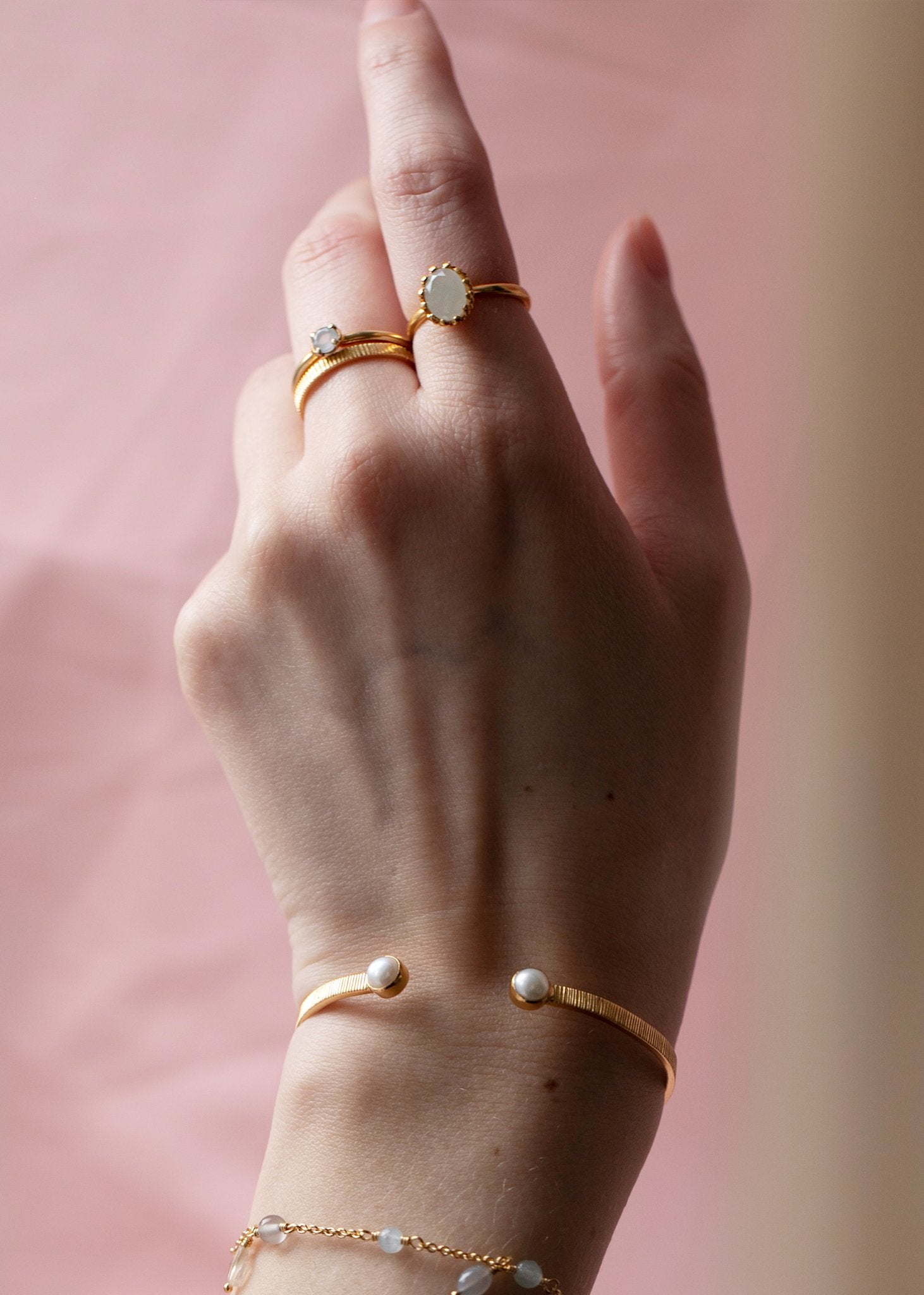 Kvindehånd med elegante vintage inspirerede ringe i guldbelagt sterling sølv med blå akvamarin ædelsten