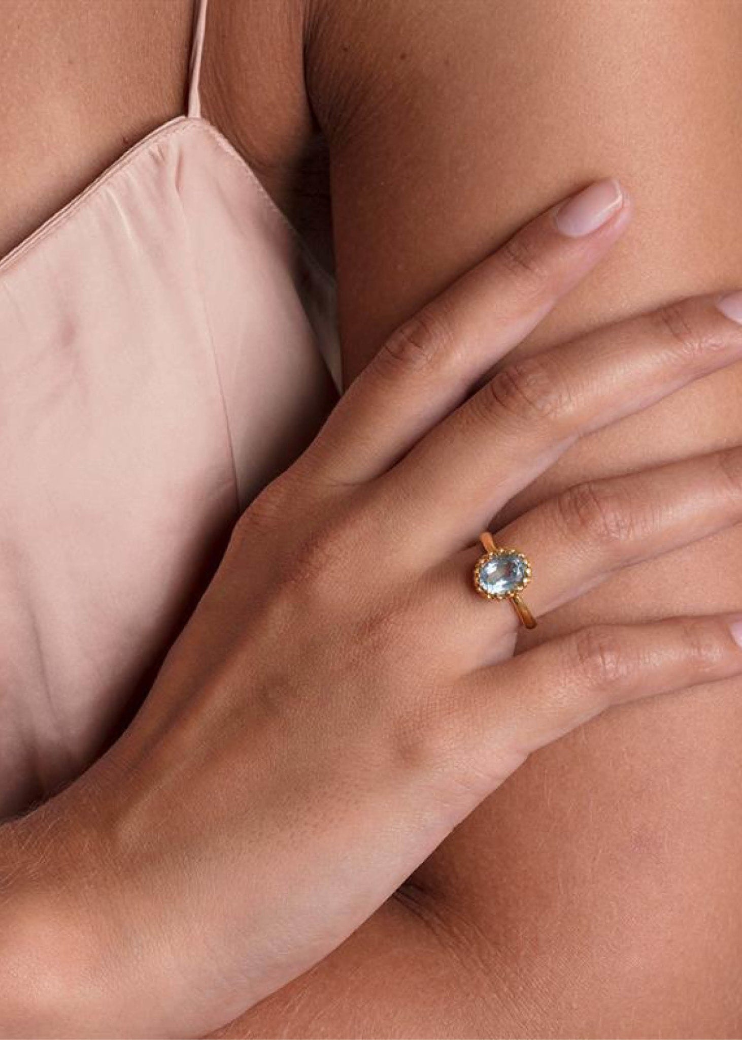 Kvinde med en Lana ring fra carré jewellery i guldbelagt sølv med en blå topas ædelsten