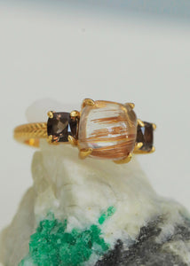 Ring in gold plated sterling silver with brown quartz gemstones and rutile quartz gemstones in a three stone design with herringbone pattern ring shank 