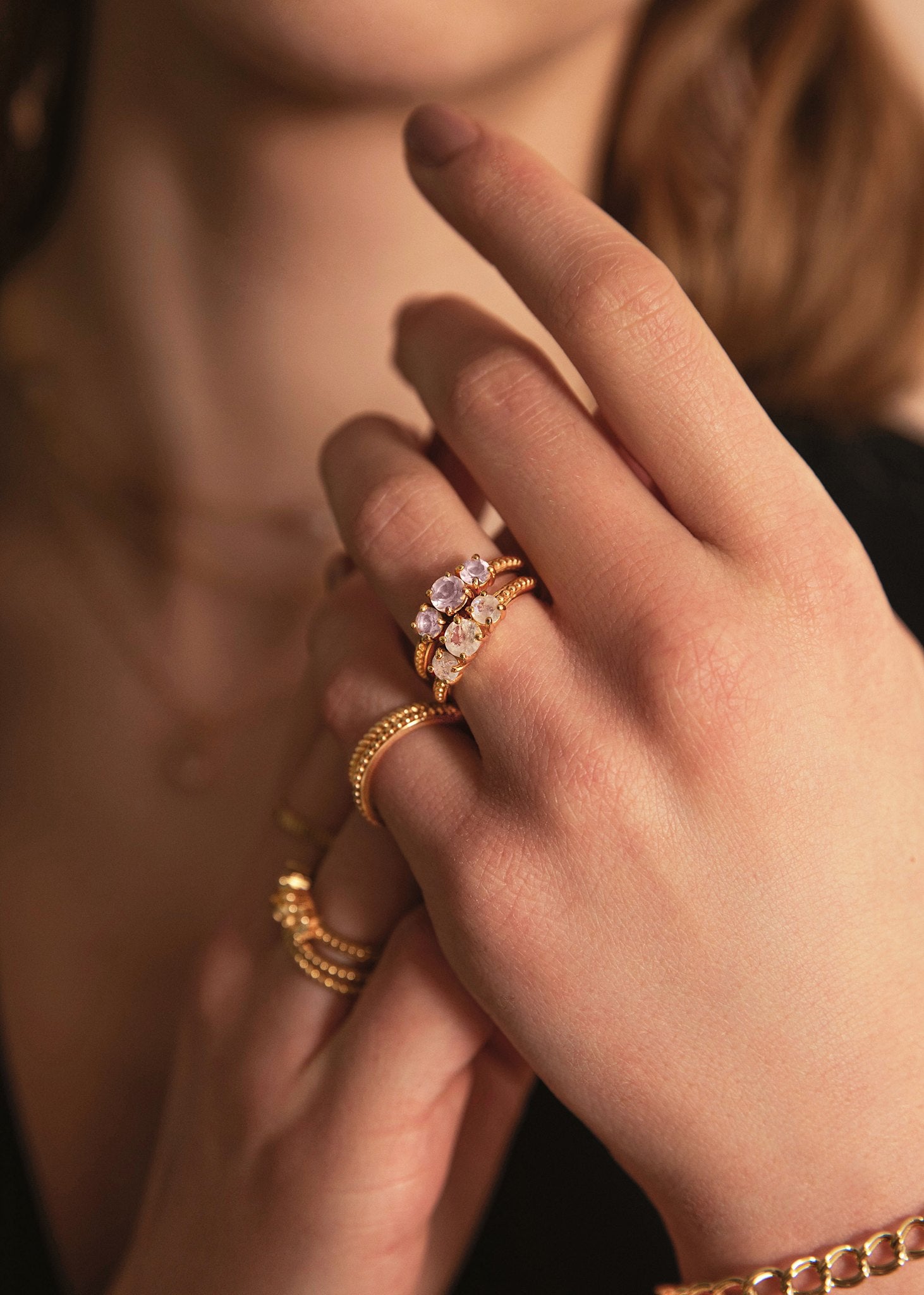 Ung kvinde med tre stens ringe med månesten ædelsten og rosa kvarts ædelsten i guld, perfekt gave til hende under 500