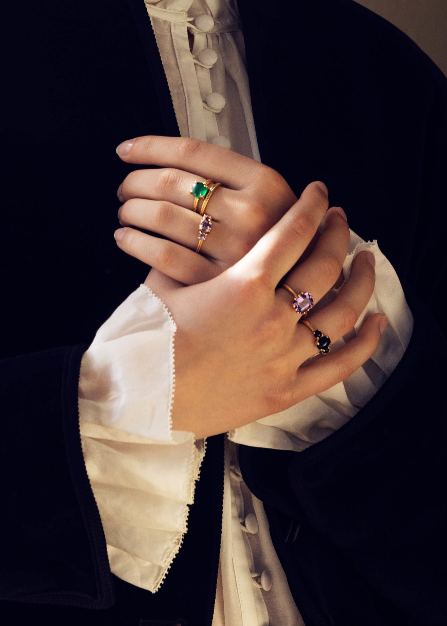 Woman wearing gold plated sterling silver rings from carré jewellery with black agate, green agate and amethyst gemstones