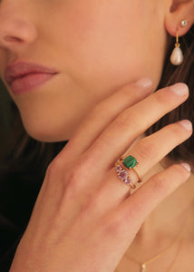 Woman with a gold plated silver ring set with cabochon-cut malachite and a ring with three facet-cut amethyst gemstones