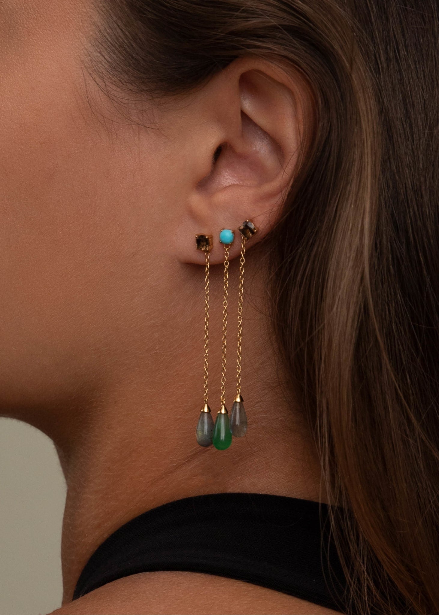Kvinde med lange guld øreringe med ægte sten fra Carré Jewellery, perfekte til gaven til hende
