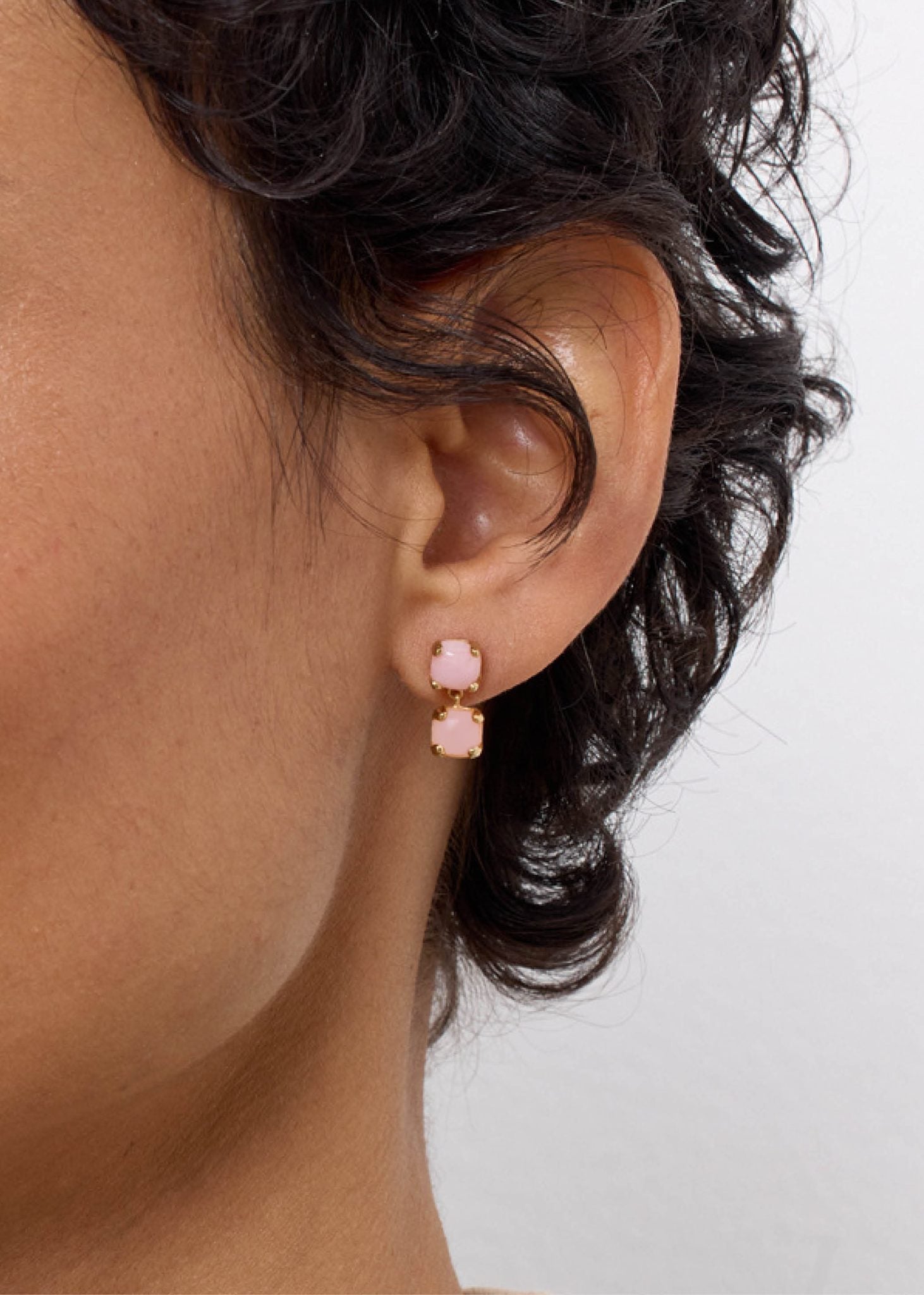 Kvinde med søde hængeøreringe til kvinder med stik lås sat med to lyserøde opal ædelsten på udsalg hos carré jewellery 
