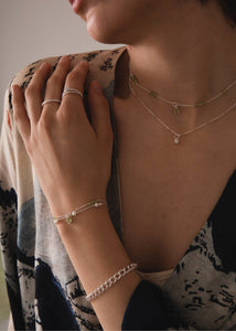 Woman with silver bracelets from carré jewellery with green peridot gemstones 