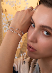 Woman with purple tanzanite bracelet with facet coin cut tanzanite gemstones for men and women in sterling silver