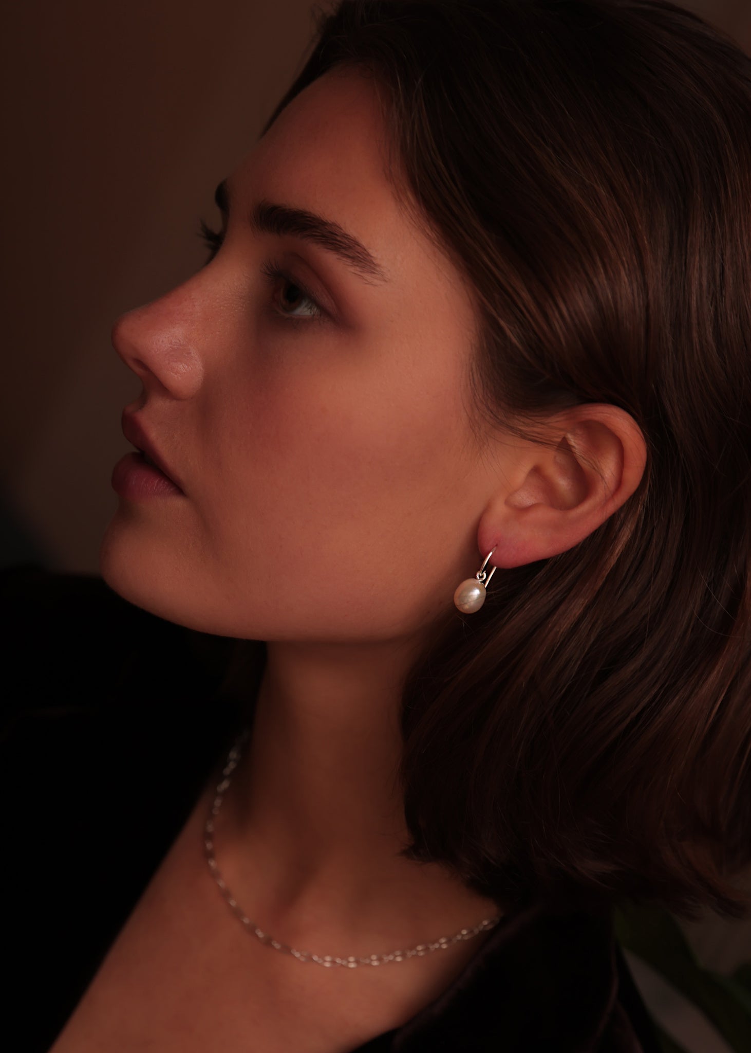 Woman wearing sterling silver earrings from Carré Jewellery with real white freshwater pearls