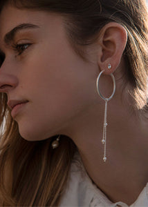 Kvinde med lange perleøreringe charms på en hoop i sterling sølv fra carré jewellery 