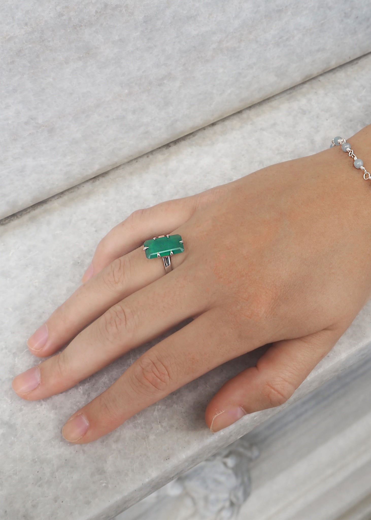 Woman wearing an emerald cut green agate ring from carré jewellery in sterling silver