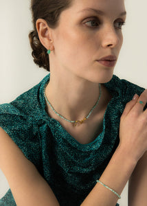 Woman wearing green chrysoprase earrings in a cabochon cut in real 10-karat solid gold with fishhook