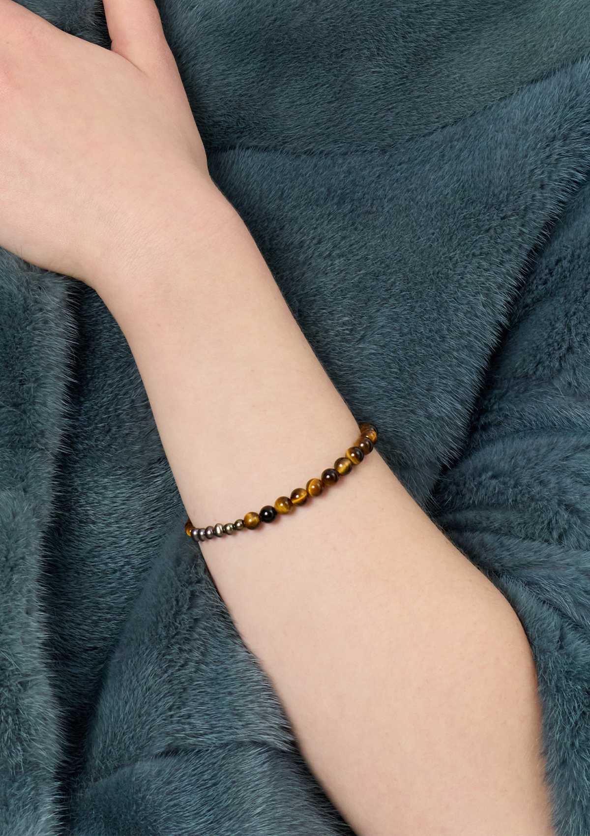 ung kvinde med tigerøje armbånd med perler, som er håndlavet i københavn af Carré