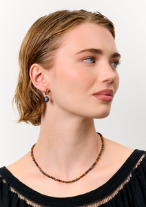 Ung kvinde med håndlavede tigerøje smykker fra carré jewellery med grå perler