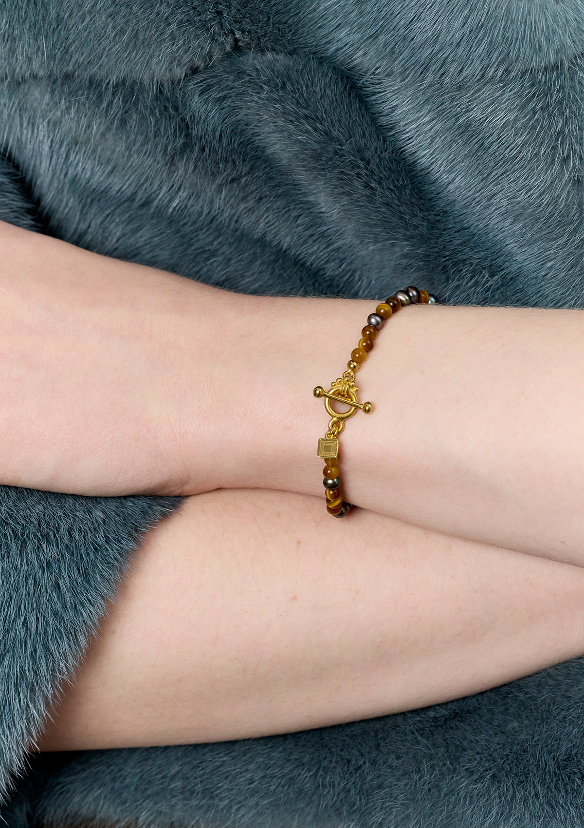 Ung kvinde med tigerøje armbånd fra carré jewellery med guld bidsellås