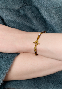 Ung kvinde med tigerøje armbånd fra carré jewellery med guld bidsellås
