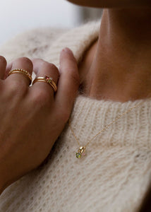 Woman with green tourmaline pendants in real 10 karat gold from carré jewellery set with facet-cut green tourmalines