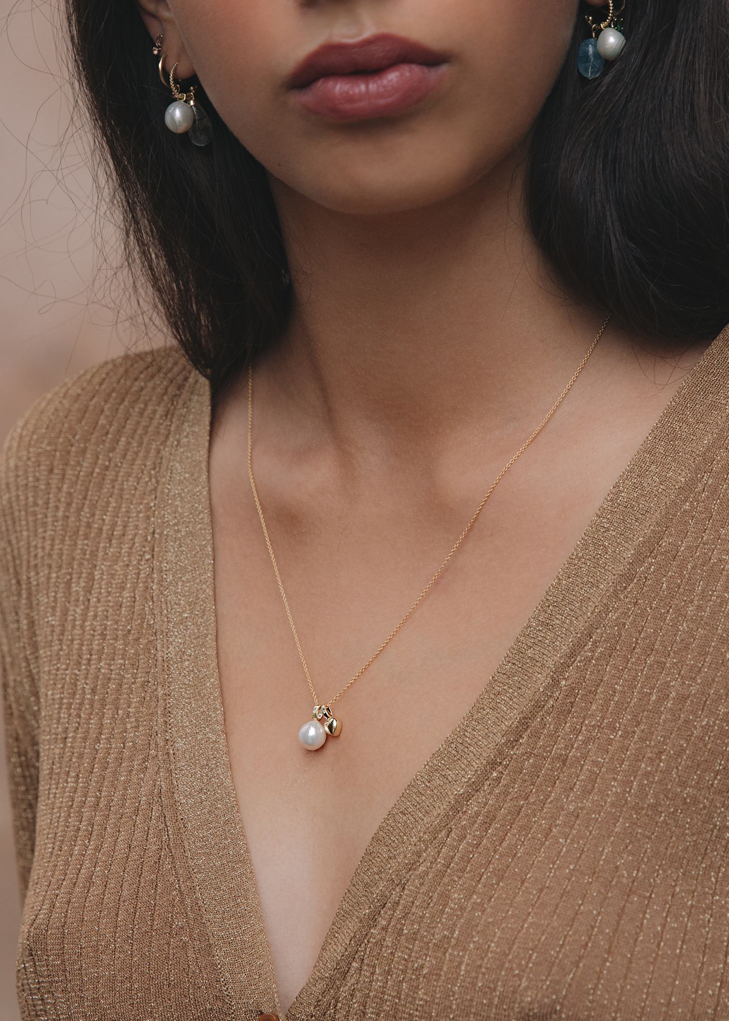 Kvinde med vedhæng i ægte 10 karat guld fra carré jewellery med ferskvandsperle og rød rubin 