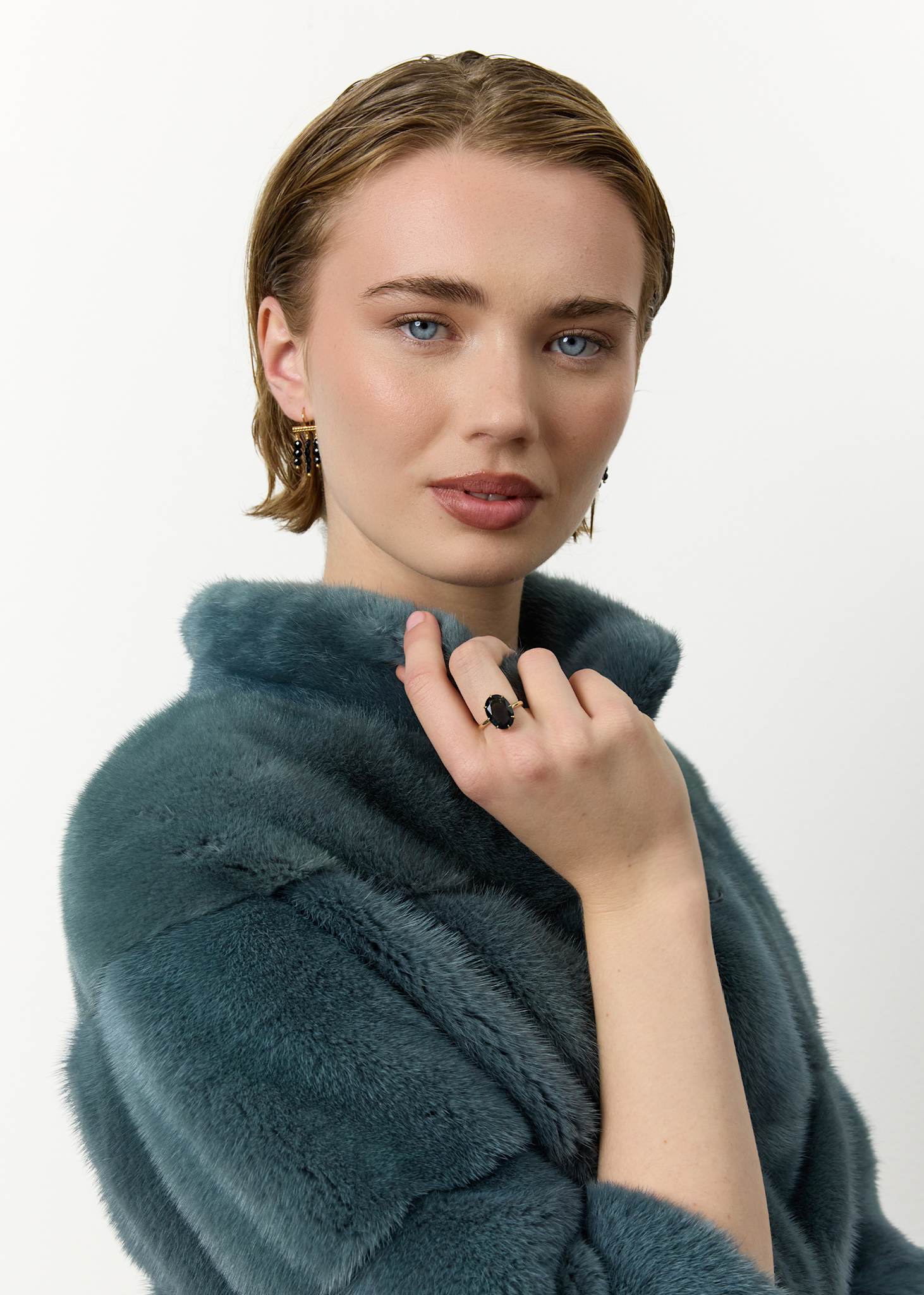 Kvinde med elegant ring i 10 karat ægte guld med en stor ovalslebet london blå topas ædelsten i cocktail stil 