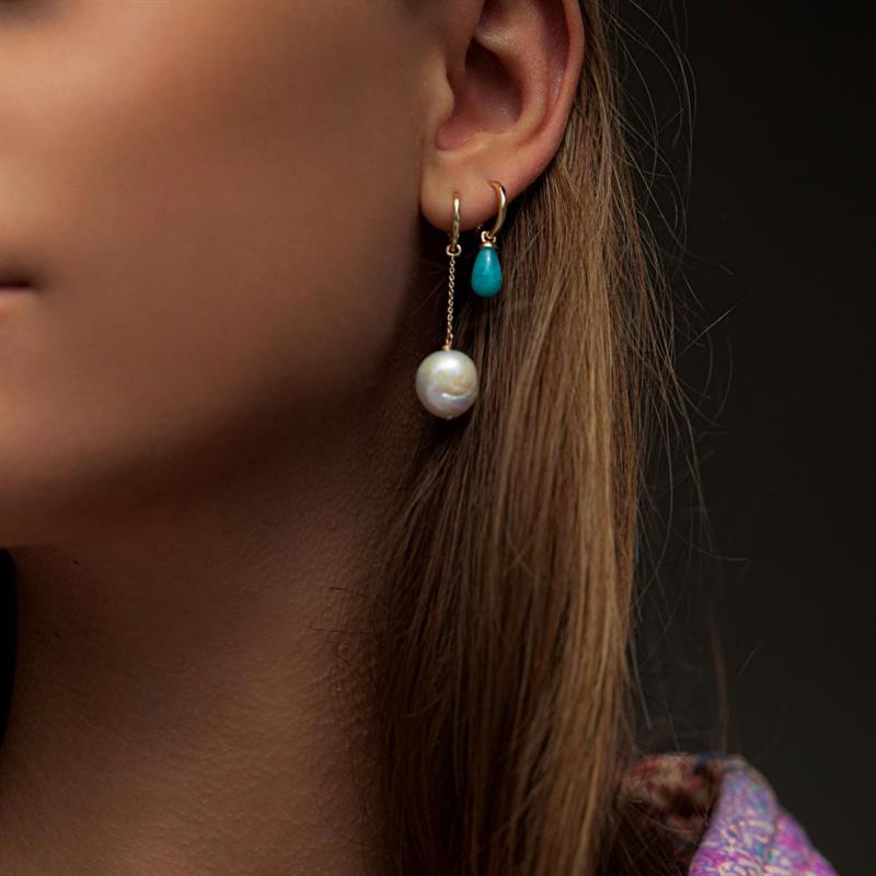 Woman with long pearl earrings in real 10 karat gold in hoops and charms style with baroque freshwater pearls 
