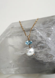 Gold plated necklace pendant with a freshwater pearl and blue topaz gemstone from carré on a figaro chain