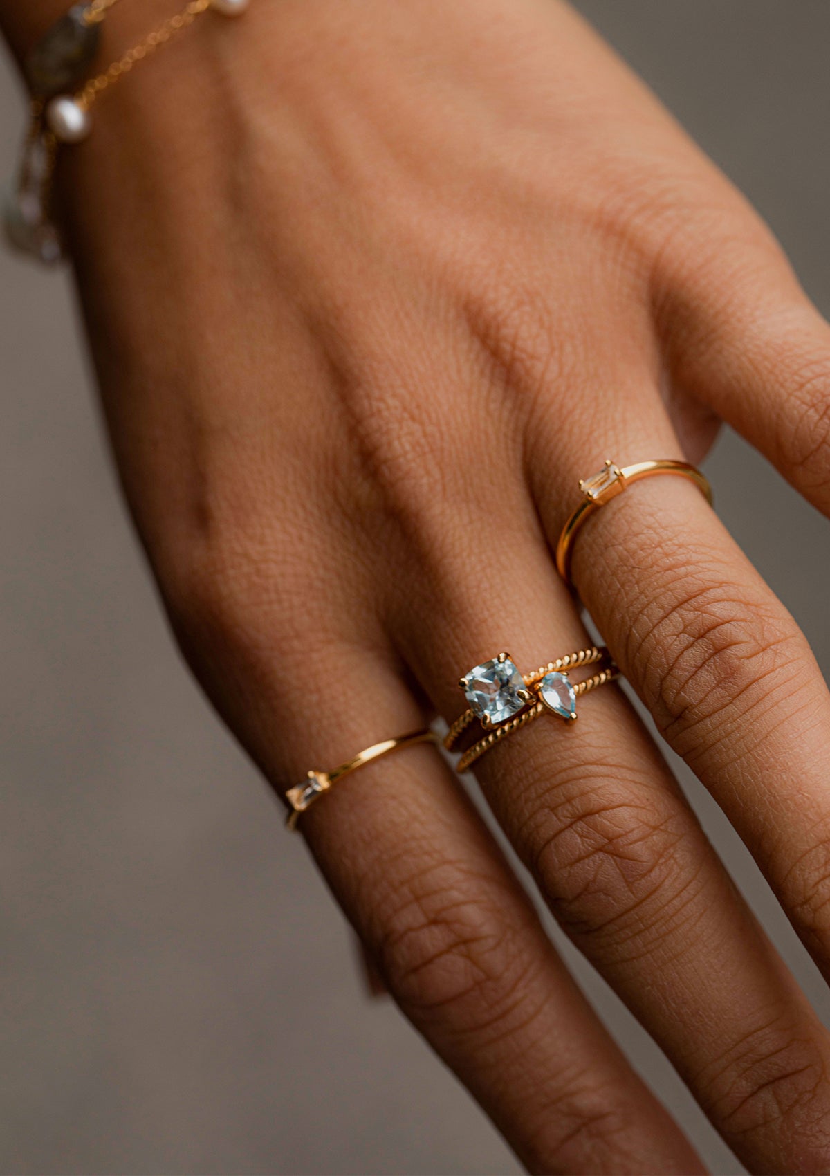 woman with gold plated rings with gemstones from carré. The blue gemstones are blue topaz and the yellow one is a citrine gemstone