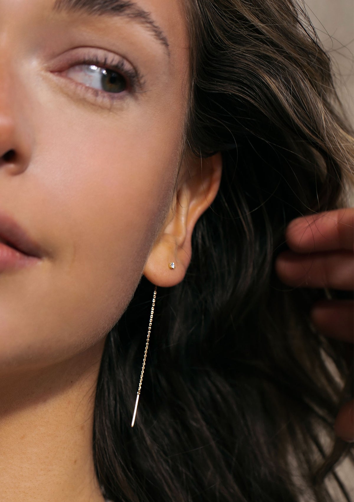 young woman with a solid gold long chain earring with diamond from carré