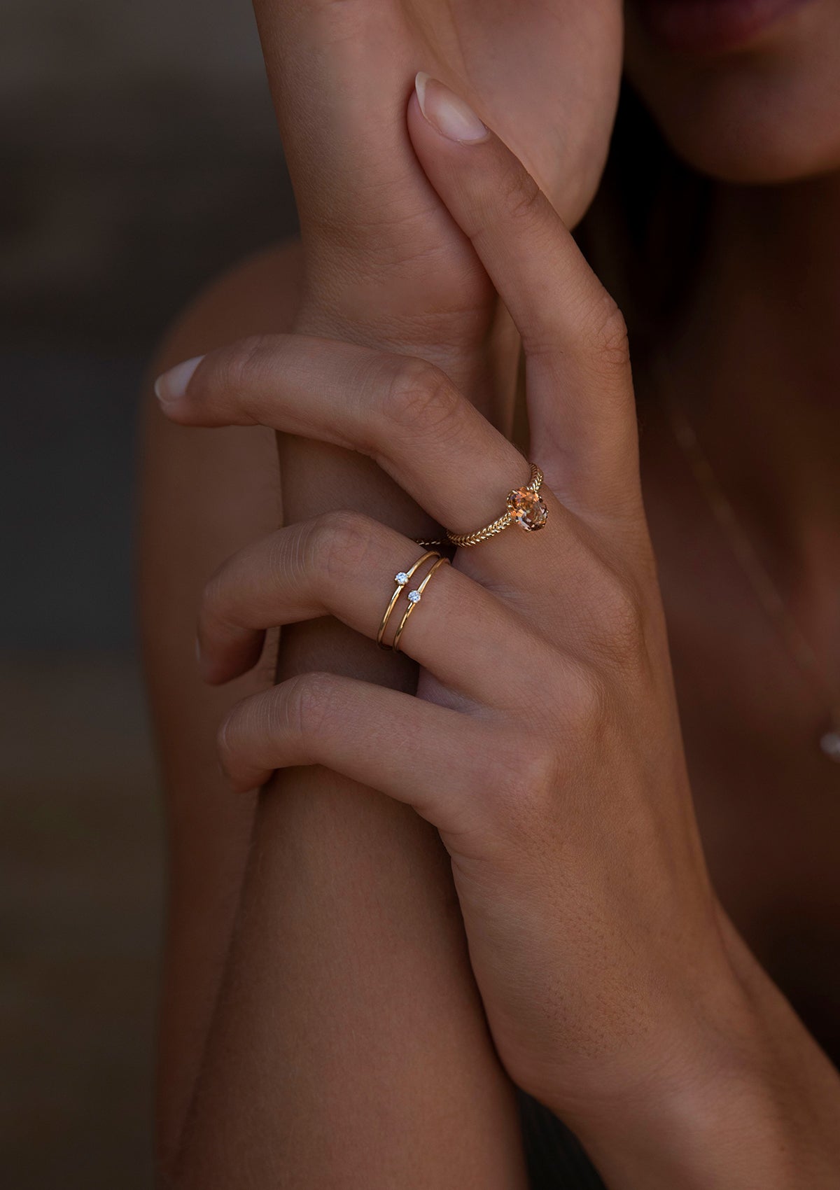 woman wearing two diamond engagement rings from carré and a large solid gold ring with champagne quartz 