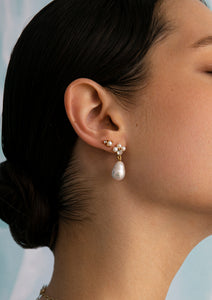 woman wearing gold plated pearl earrings with white topaz from carré