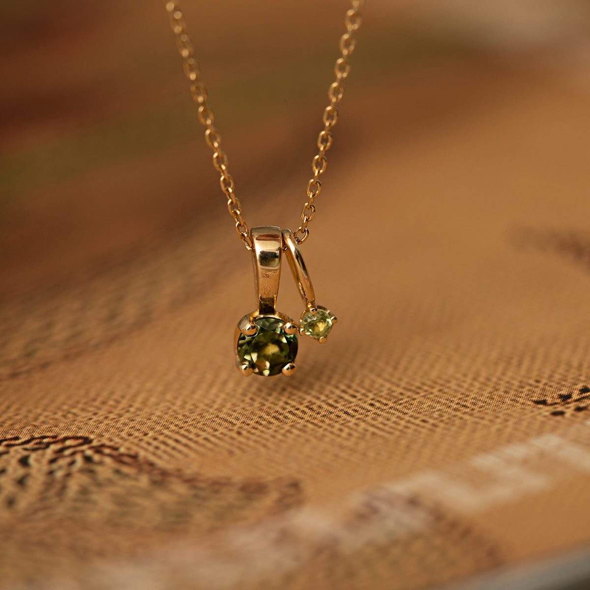 two solid 10 karat gold pendants for necklaces with facet-cut green tourmaline gemstones in prong settings