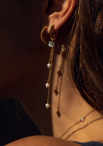 woman with gold plated long pearl earrings from carré, and a hoop with a labradorite charm